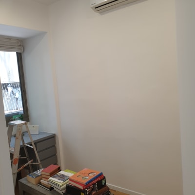 סולם עם כתמי צבע ליד קיר לבן