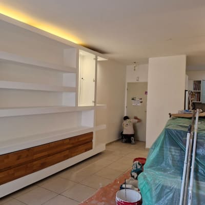 אדם עובד על קיר עם כלים וחומרים לשיפוץ