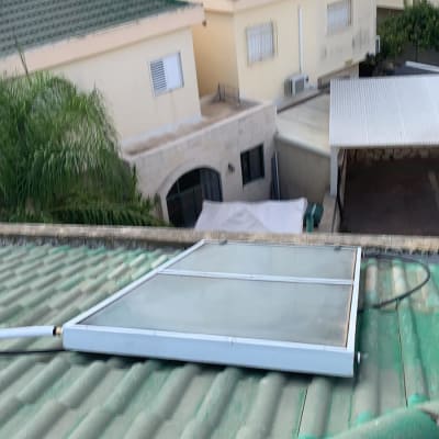 קולטן שמש מותקן על גג רעפים ירוק