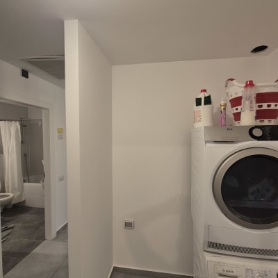 חדר כביסה עם מכונת כביסה ומייבש