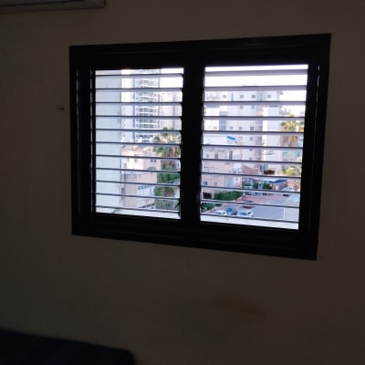 חלון עם תריסים אופקיים פתוחים חלקית