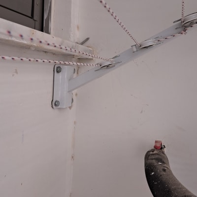 מתקן כביסה עם חבלים ומסגרת מתכת על קיר