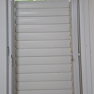 תריסים לבנים מותקנים בחלון