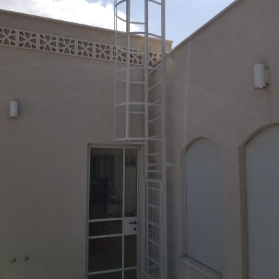 סולם מתכת לבן ליד דלת זכוכית