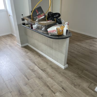 רצפת פרקט עץ בהירה בחדר עם קיר לבן