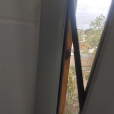 חלון עם תריס פתוח ונוף חיצוני מטושטש