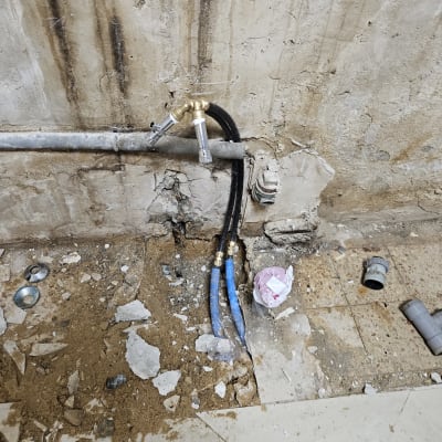 צינורות מים כחולים וחיבורים על קיר בטון חשוף