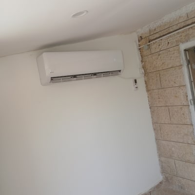 מזגן מותקן על קיר לבן בחדר