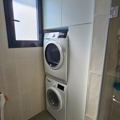 מכונת כביסה ומייבש בערימה בחדר כביסה קטן