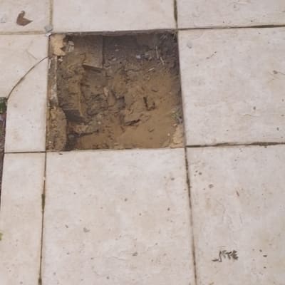 מרצפת חסרה ברצפת קרמיקה עם אדמה חשופה