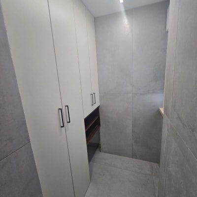 ארונות לבנים עם ידיות שחורות בחדר קטן