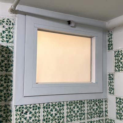 חלון אלומיניום קטן עם מסגרת לבנה