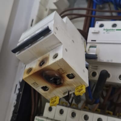 לוח חשמל עם מפסק שרוף וחוטים חשמליים