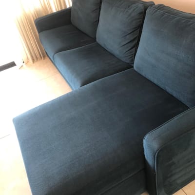 ספה כחולה ליד וילון בהיר