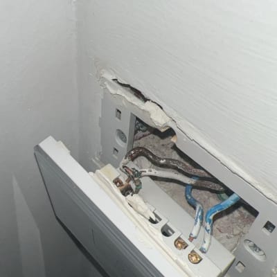 שקע חשמלי פתוח עם חוטים חשופים בקיר