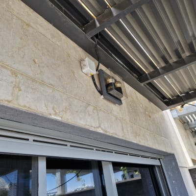 תאורה חיצונית מותקנת על קיר מתחת לגג מתכת