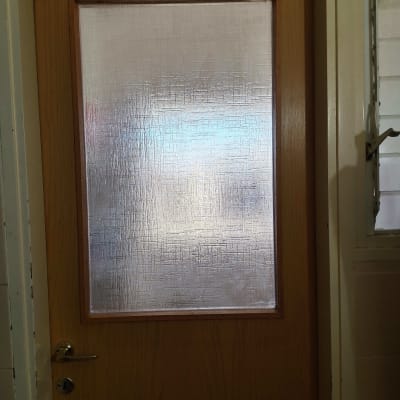 דלת עץ עם זכוכית מטושטשת במרכז