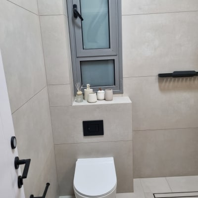 שירותים מודרניים עם אריחים בהירים וחלון קטן