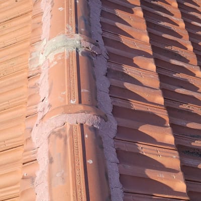 גג רעפים חום עם חיבורי מלט בין הרעפים