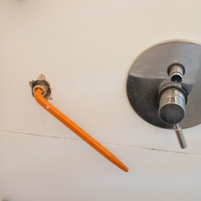 מוט כתום מחובר לצינור בקיר לבן