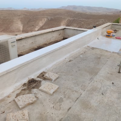 גג עם חומרי איטום, דלי צבע ומברשת