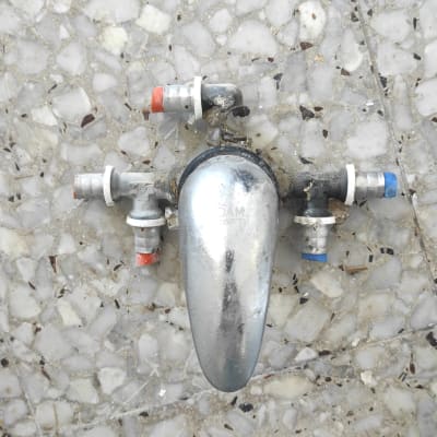 ברז מתכת עם חיבורים צבעוניים על רצפה