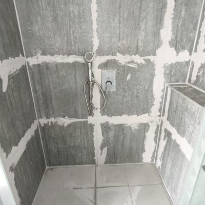 מקלחת בבנייה עם אריחים וכלי עבודה