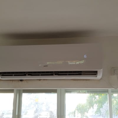 מזגן מותקן על קיר מעל חלון