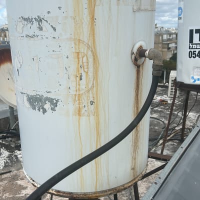 דוד שמש ישן עם חלודה וצינור מחובר