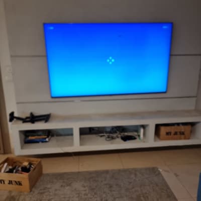 טלוויזיה מותקנת על קיר עם מדף תחתון