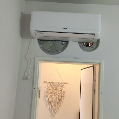 מזגן מותקן על קיר מעל דלת פתוחה