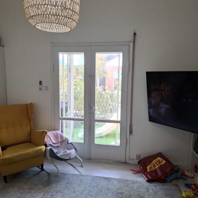 דלת זכוכית עם נוף חיצוני, כורסה צהובה ושטיח אפור