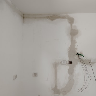 קיר עם חוטי חשמל חשופים ושקעים