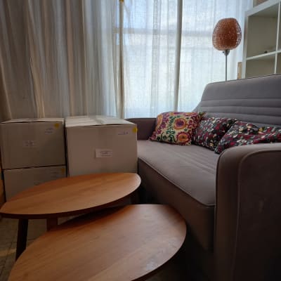 קופסאות קרטון ליד ספה עם כריות צבעוניות