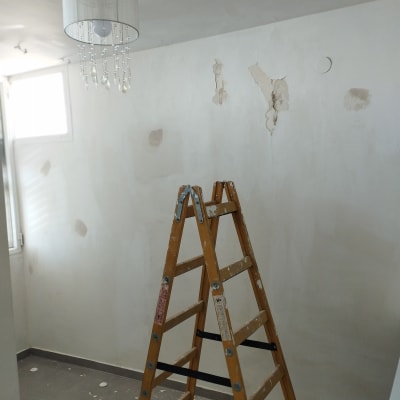סולם עץ בחדר עם קירות מתקלפים