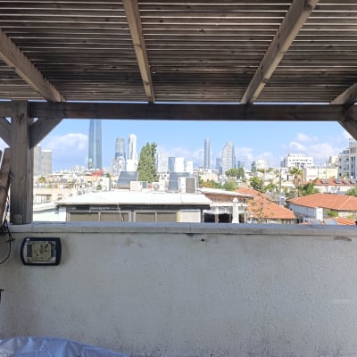 פרגולה מעץ עם נוף לעיר ברקע