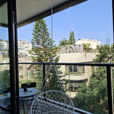 מרפסת עם כיסא תלוי ונוף עירוני