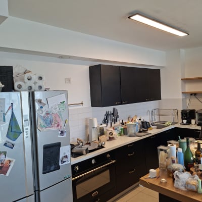 מטבח עם ארונות שחורים וכלים על השיש