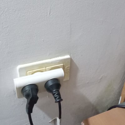 שני תקעים מחוברים לשקע חשמלי בקיר