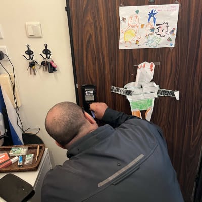 אדם עובד על מנעול דלת עם מפתחות תלויים