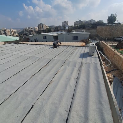 אדם עובד על איטום גג עם יריעות ביטומניות