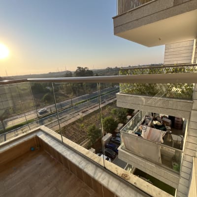 מרפסת עם רצפה רטובה ומעקה זכוכית בשקיעה