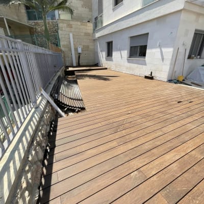בניית דק עץ גדול בחצר בית פרטי