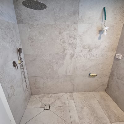 מקלחת עם ראש גשם, אריחים חדשים ונורה תלויה