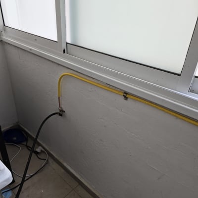 צינור גז צהוב מחובר לקיר ליד חלון