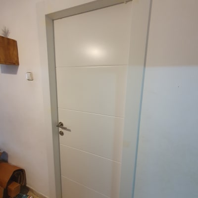 דלת לבנה עם ידית מתכת כסופה