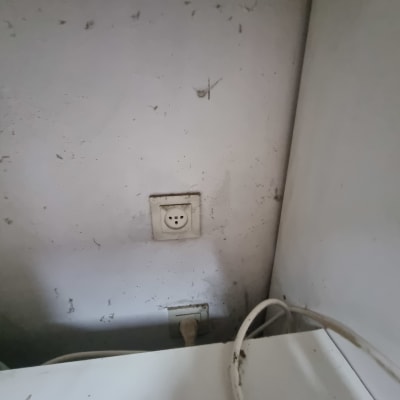 שקע חשמל עם כבל מחובר לקיר מלוכלך