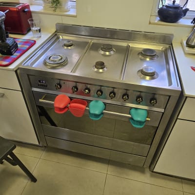 תנור גז עם כפתורים ומחזיקי סיליקון צבעוניים