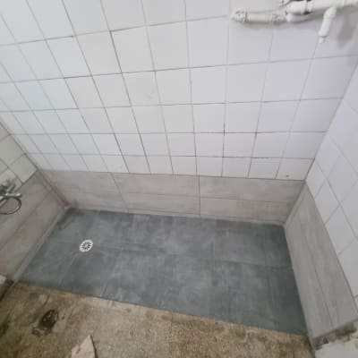 שיפוץ מקלחת עם אריחים חדשים על הרצפה והקירות