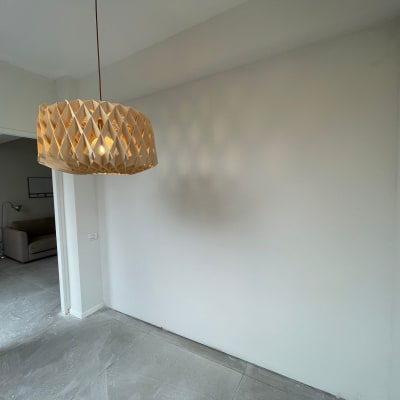 קיר גבס לבן עם מנורת תקרה מעוצבת